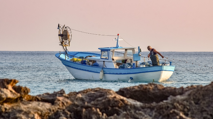 Barca de pesca en la costa al amanecer