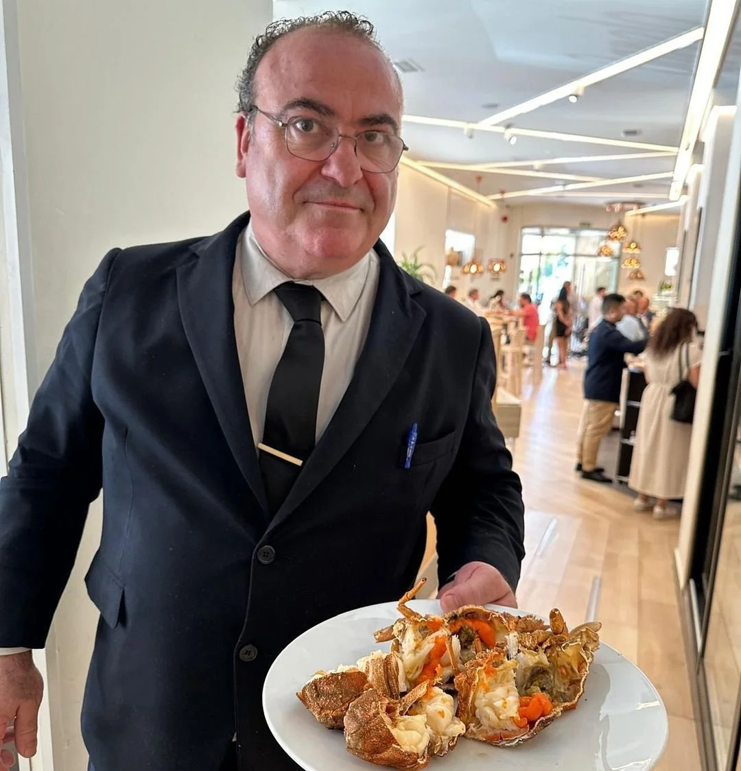 Ogrelo waiter carrying a seafood platter through the dining room