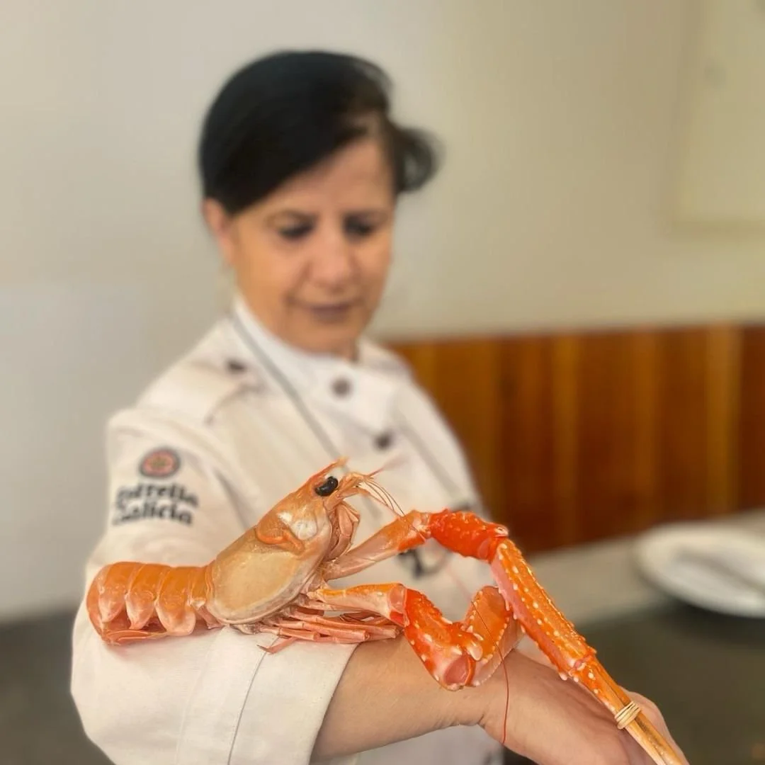 Cocinera de Ogrelo con marisco sobre el brazo