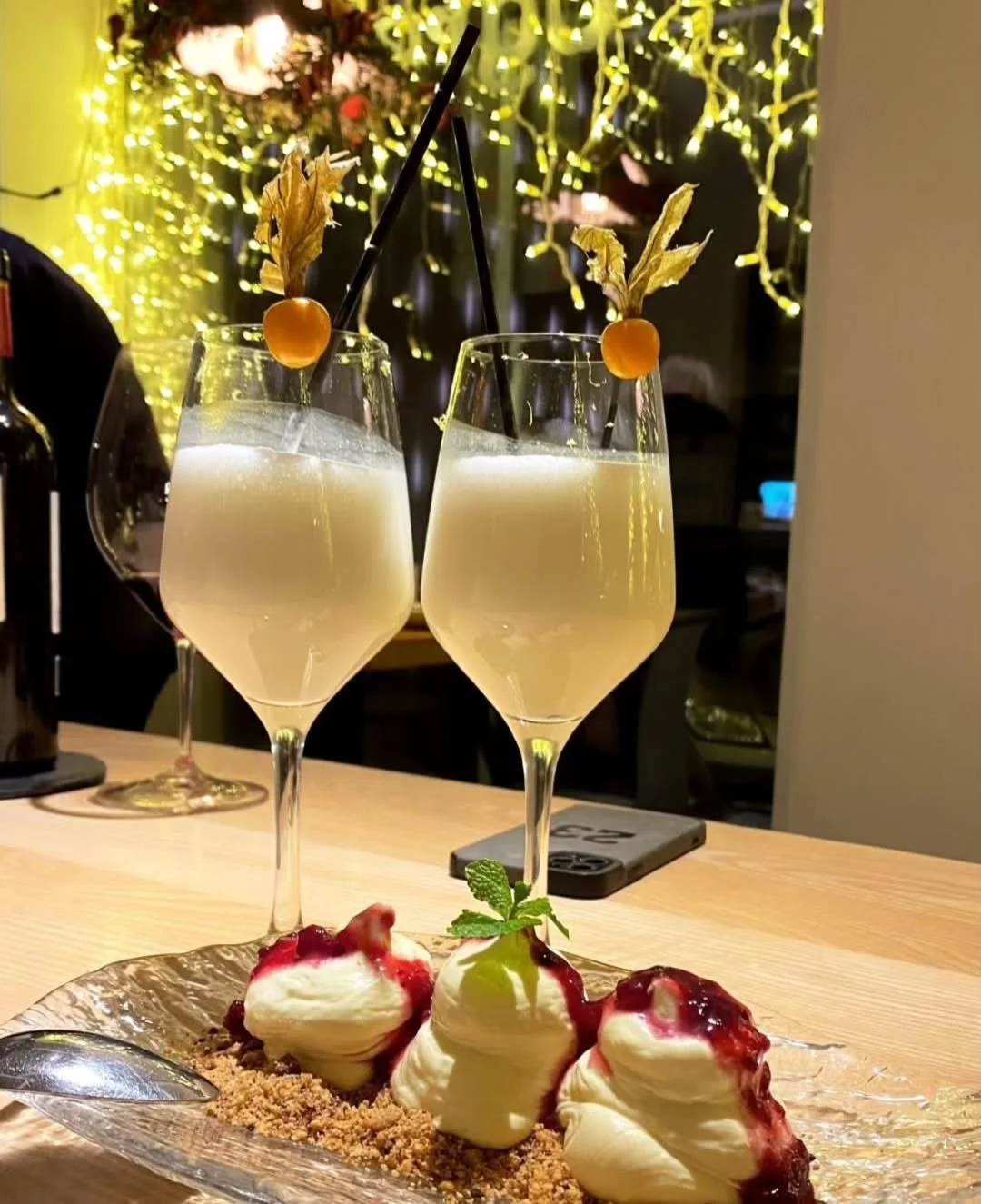 Dos copas de cava y un postre en la barra