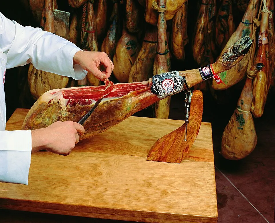 Cortador de jamón trabajando sobre una tabla de madera