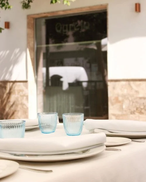 Entrada de Ogrelo y mesa con vasos azules