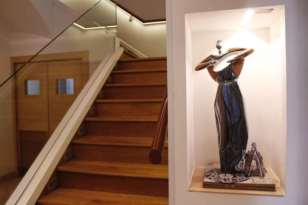 Escalera de madera y escultura en el interior de Ogrelo