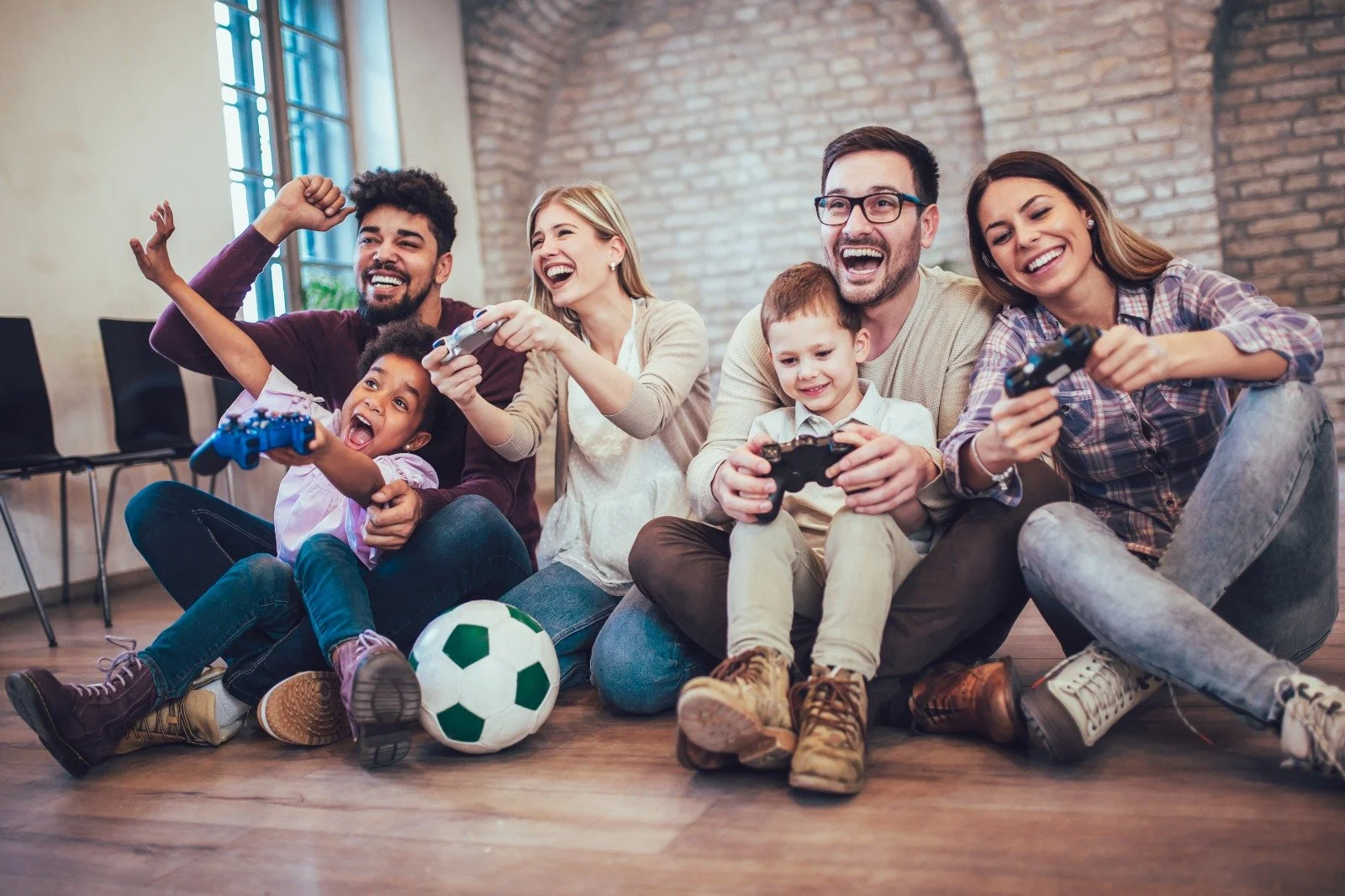 Familia jugando a videojuegos en el suelo del salón