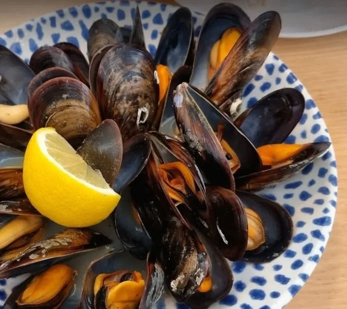Mejillones al vapor con limón en un bol azul