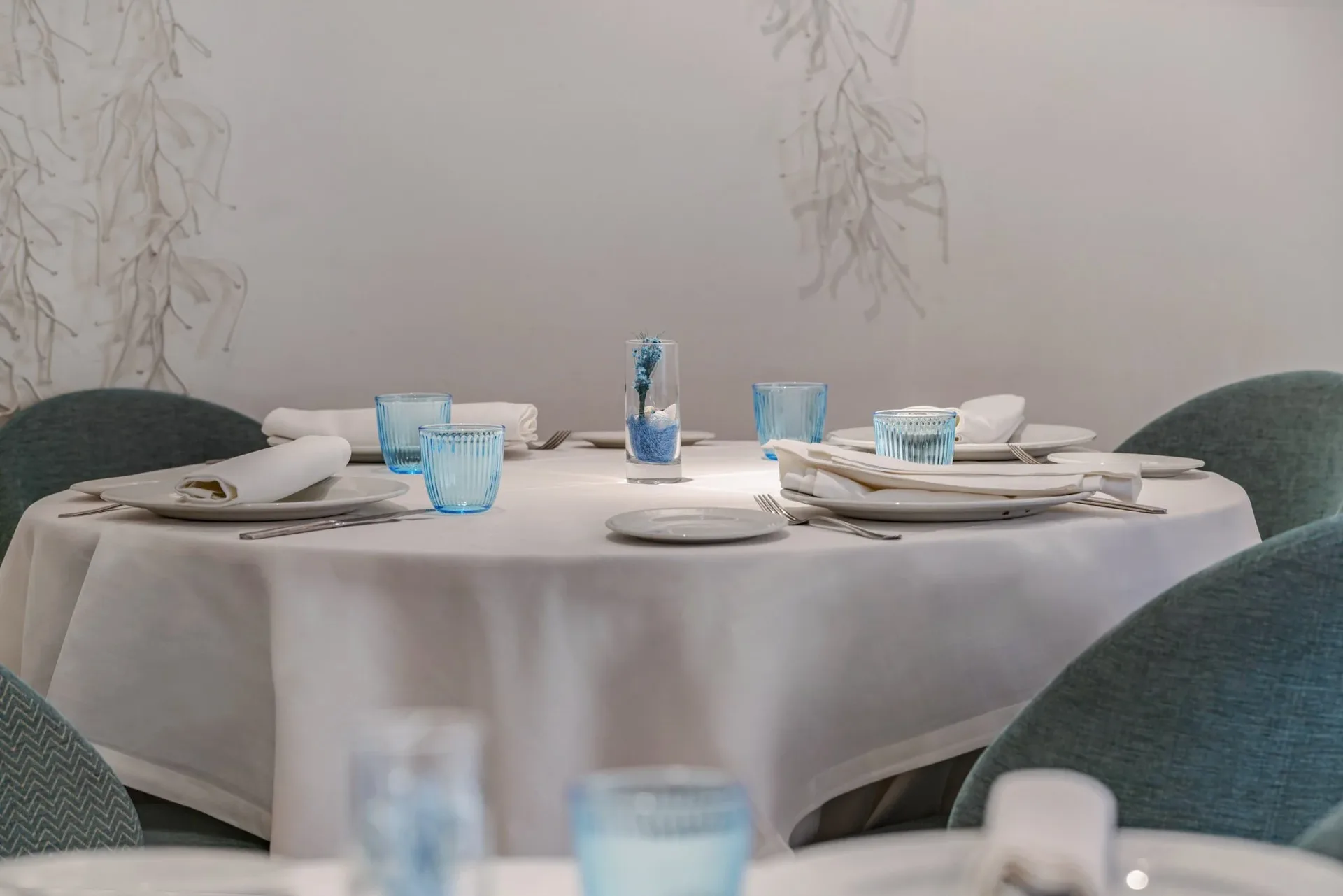 Round table with a white tablecloth and blue glasses in one of Ogrelo's private dining rooms