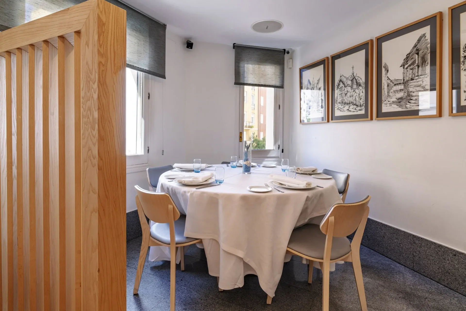Dining corner with a round table and paintings of old Madrid