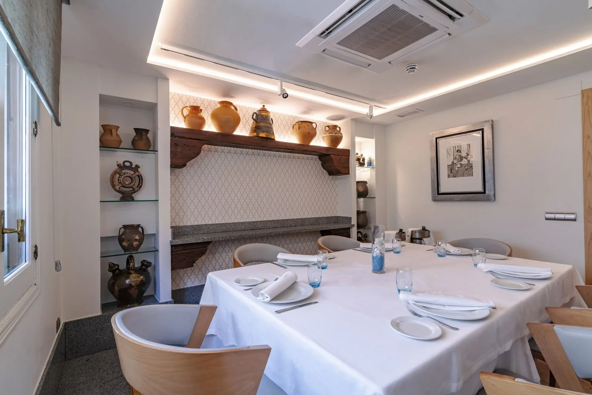 Room with a Galician ceramics display and a table set for a group