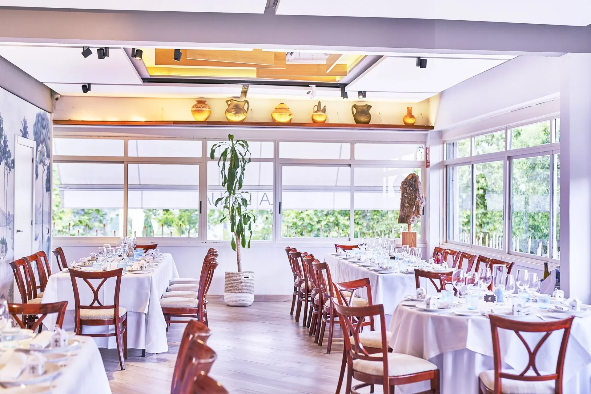 Bright dining room with large windows and set tables
