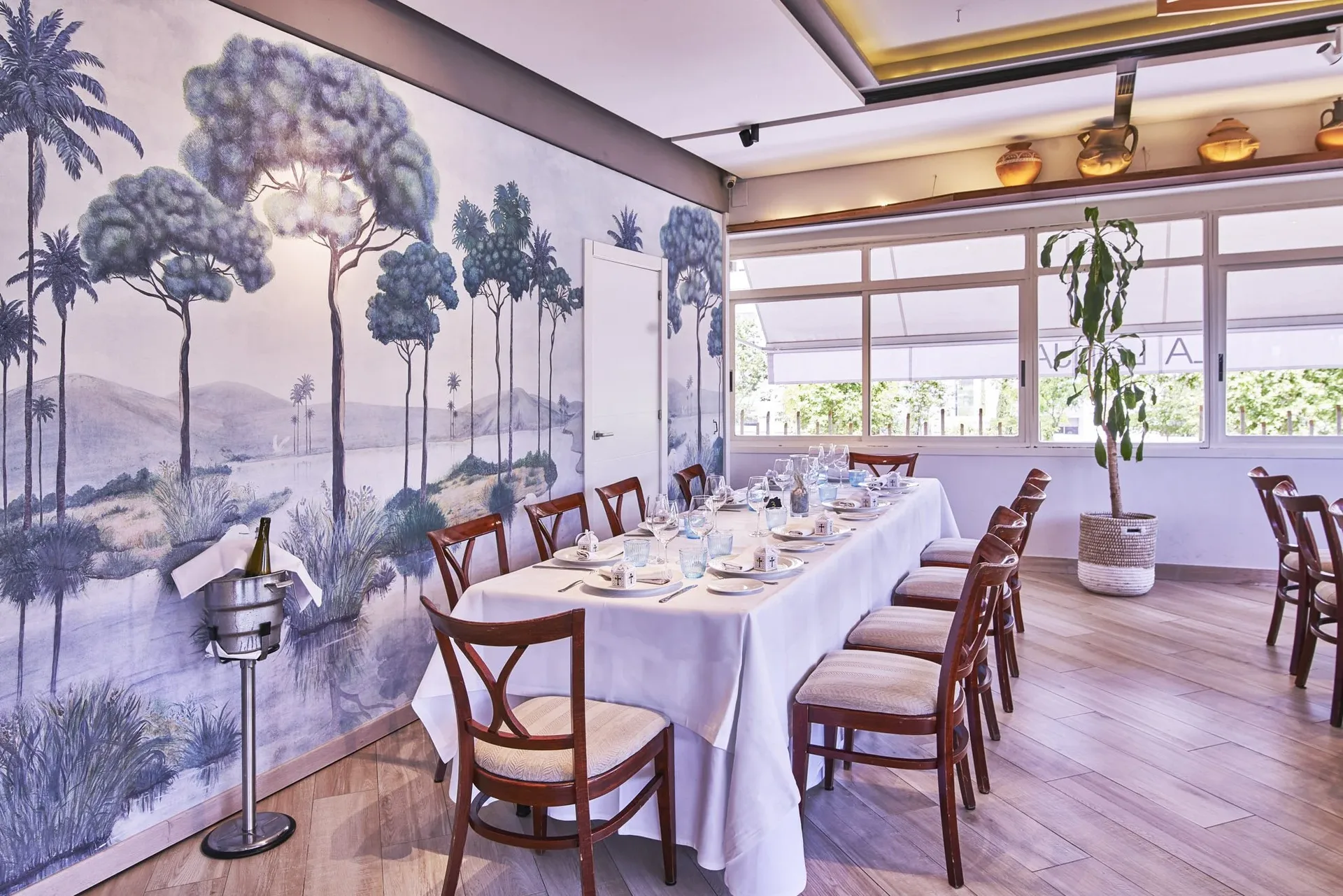 Room with a mural and a long table set for a group