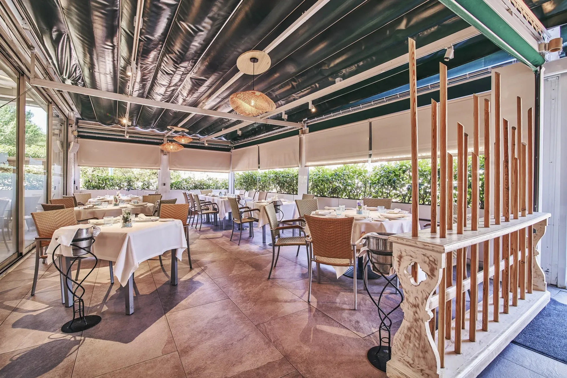 Covered terrace with wooden railing and set tables